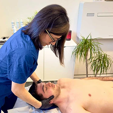 Elisa Saviano esegue una palpazione cervicale durante una valutazione osteopatica